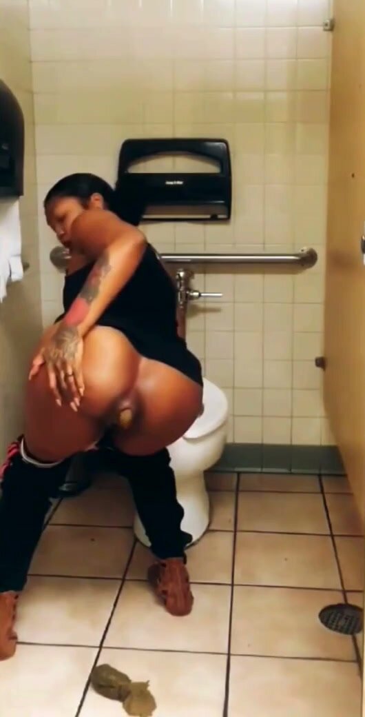 Black woman shitting on stall floor of public toilet - video 2