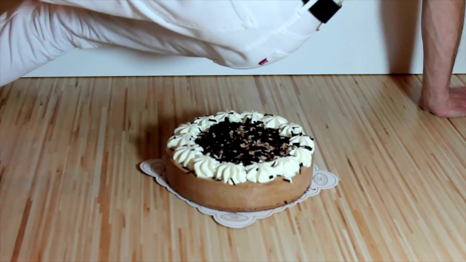 Guy in white jeans sits on creamy gateau and gets messy
