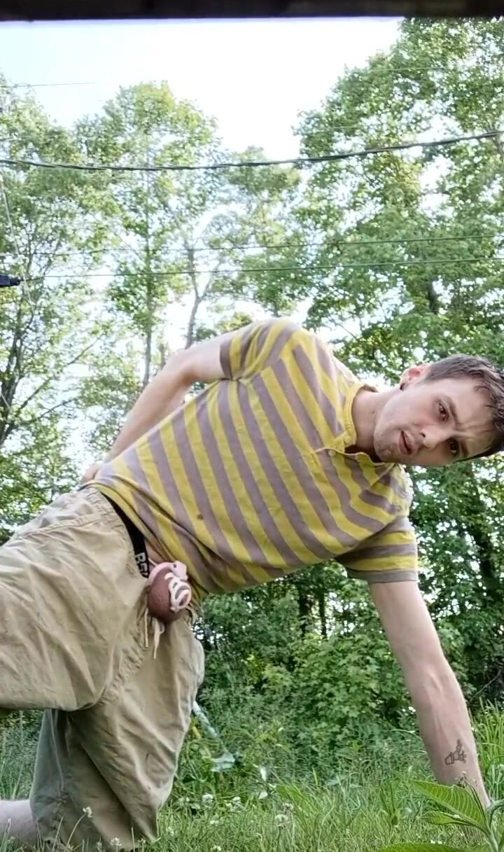caged guy pissing outdoors