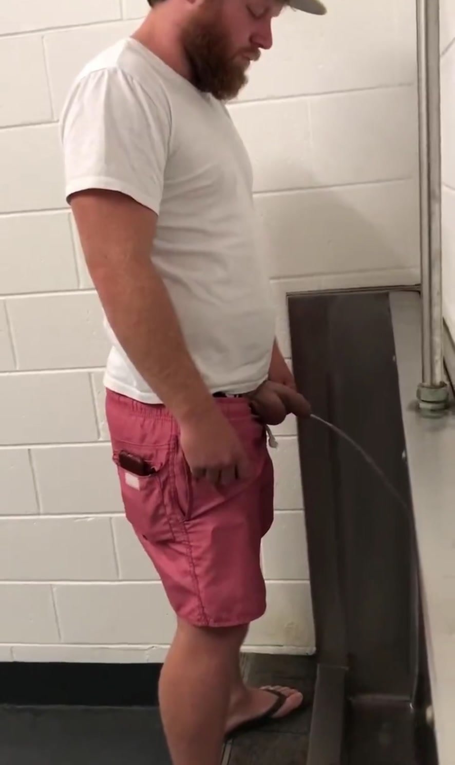 Two guys spy at urinal
