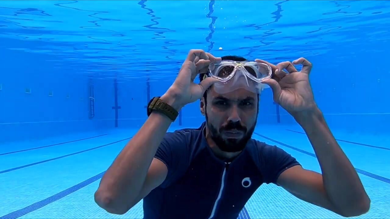 Spanish cutie in wetsuit taking mask off underwater