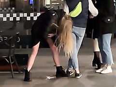 Male friend helps drunken,pissing lady keep her balance