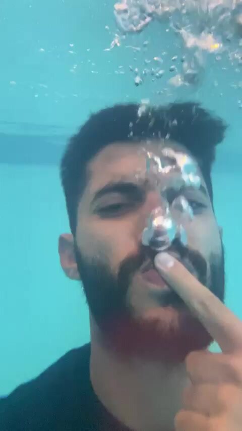 Barefaced arab blowing his air out underwater