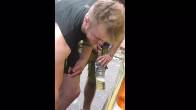 Two men pee in a bottle