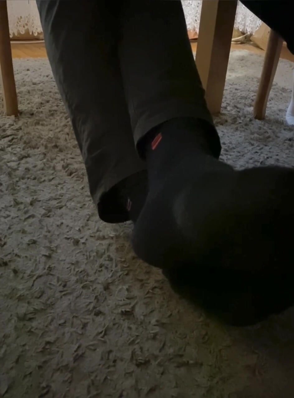 my uncle shows me his black sweaty socks under the tabl