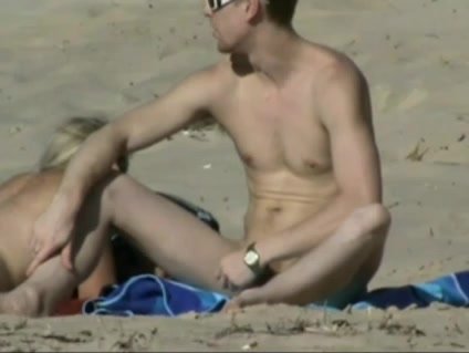 Straight nudist couple having fun on beach