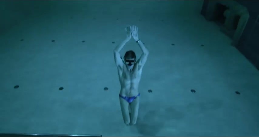 Italian freediver underwater in blue speedos