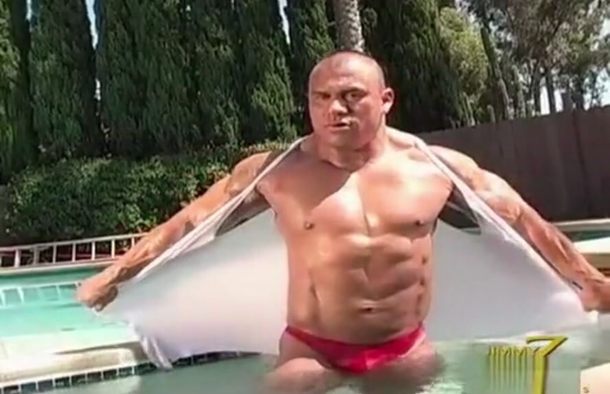 Big bodybuilder flexing in the pool