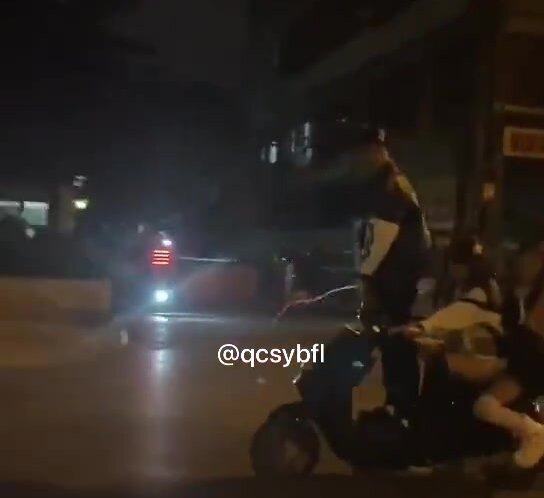 Asian guy pissing while in scooter with two girls