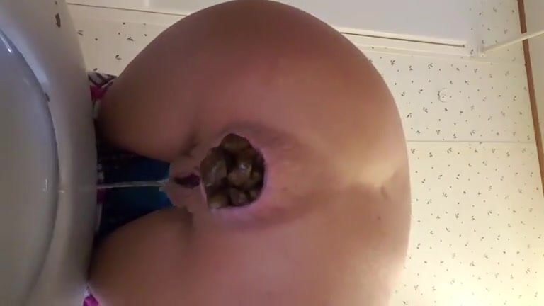 Cute girl pushing out a massive turd over the toilet