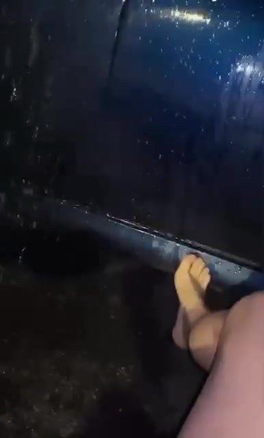 Barefoot girl washes the car door with massive gush