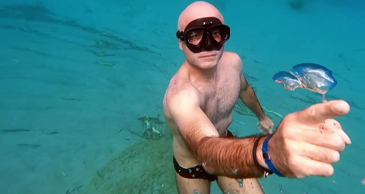 Underwater bald freediver in speedos