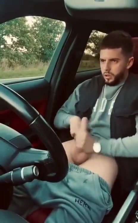 Handsome bearded guy jerking off in his car
