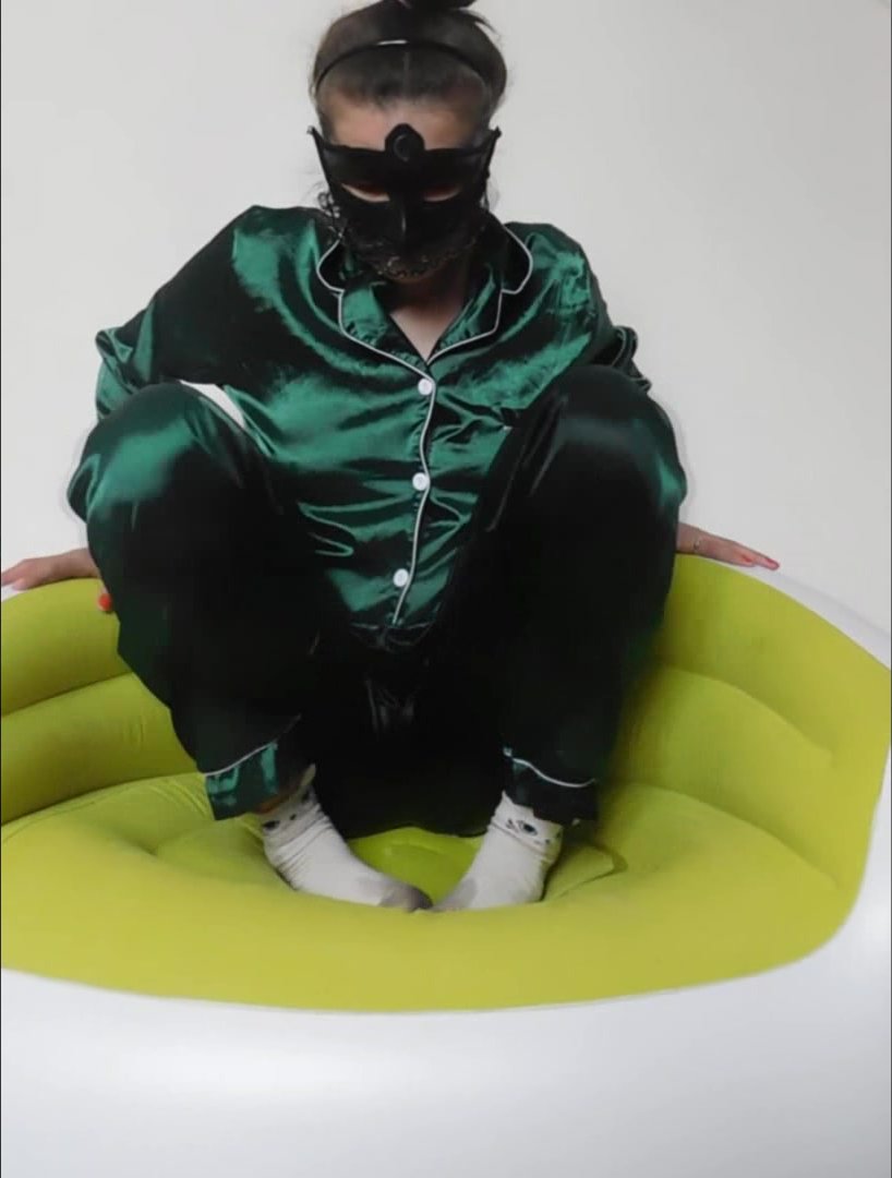 Girl pees in satin pajama sitting in inflatable chair