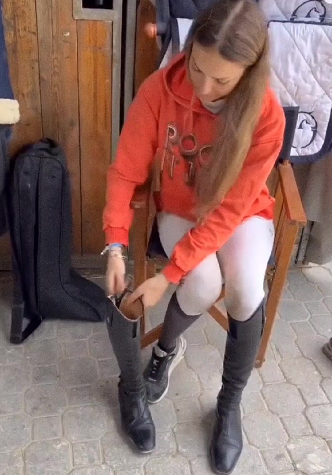 A sexy rider puts on her riding boots
