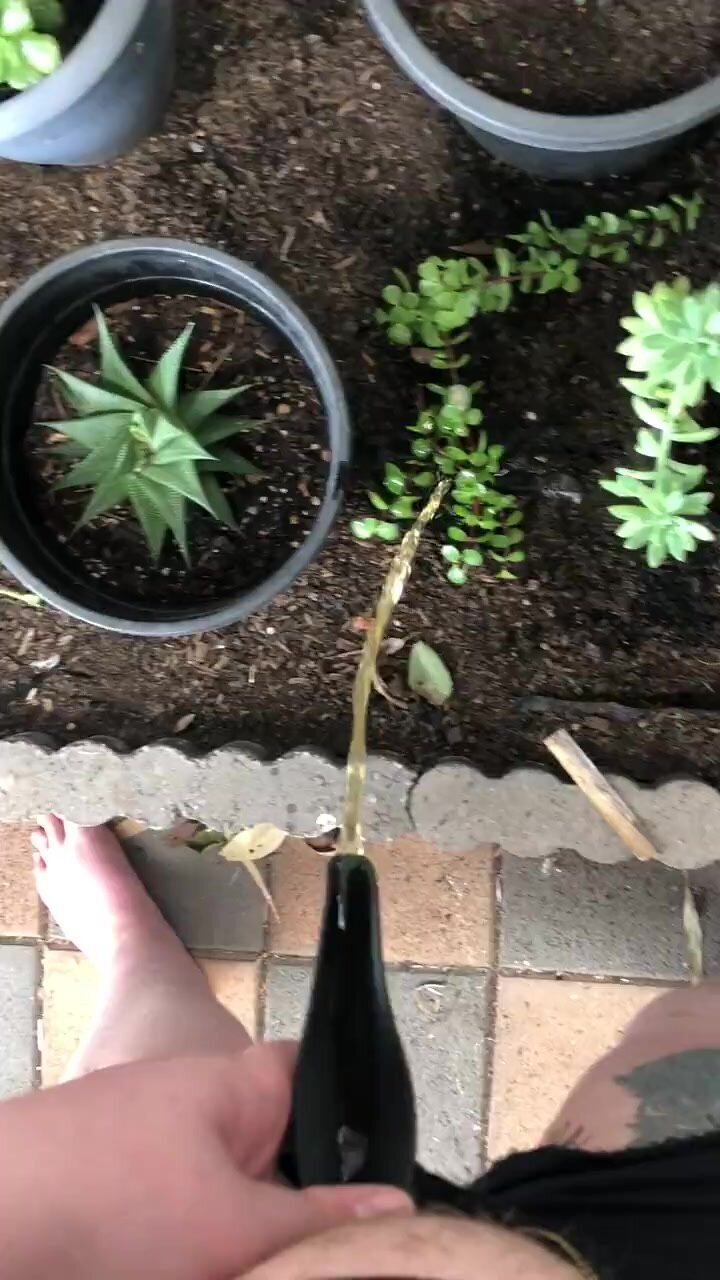 Barefoot cutie uses she-wiz to water the flowers
