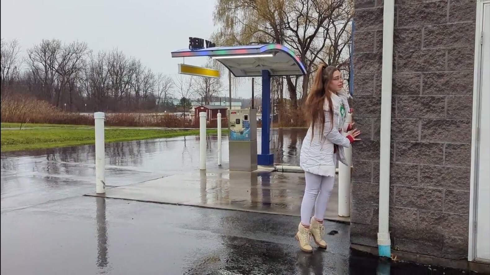 Cute girl pissing outside a car wash