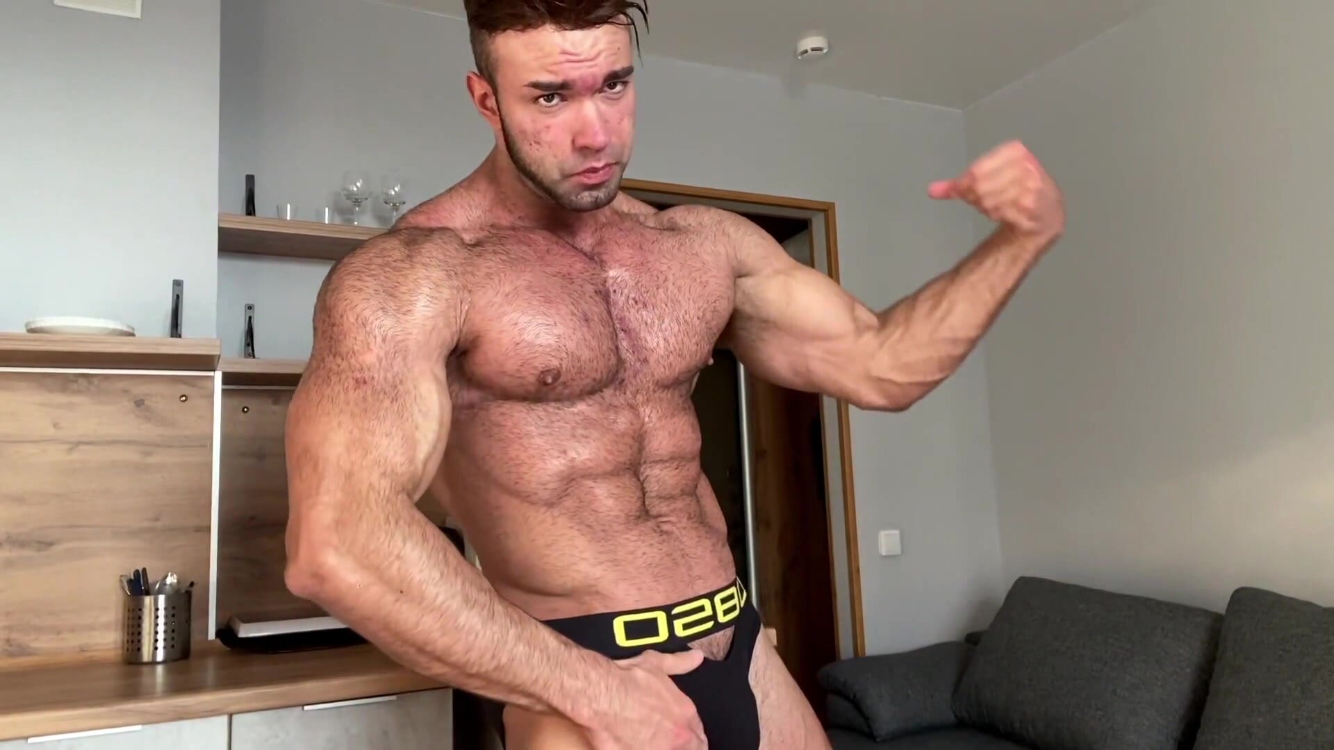 young hairy bodybuilder flexes his muscles